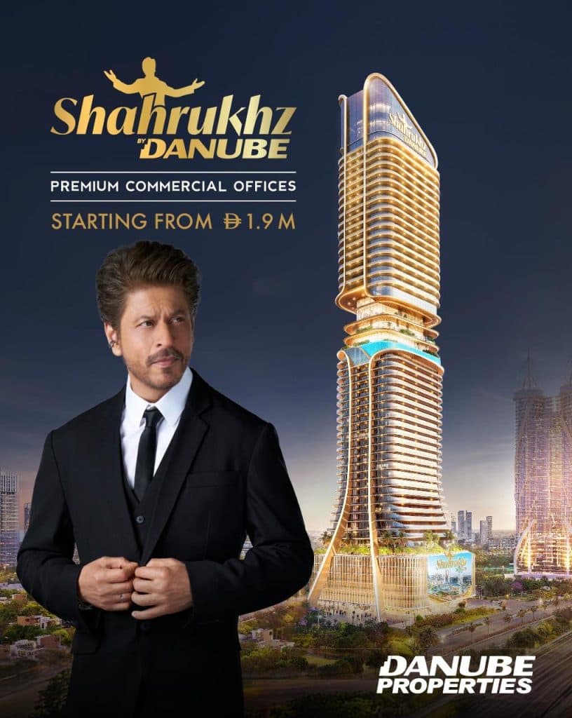 Shah Rukh Khan posing beside a luxury skyscraper for Shahrukhz by Danube premium commercial offices.
